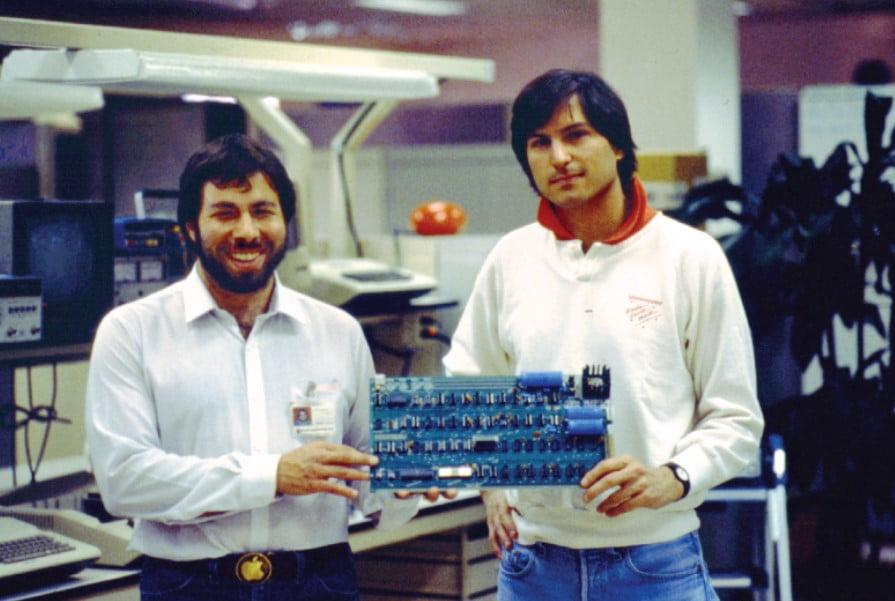 Steven Jobs (sağda) ve Stephen Wozniak ellerinde Apple I devre kartı tutarken. 1976.