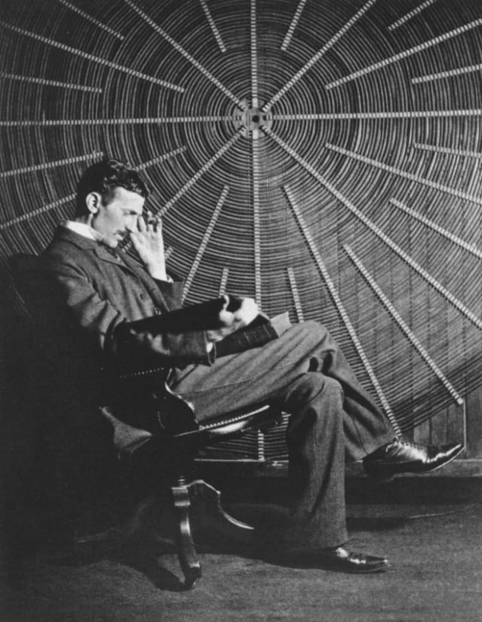 Nikola Tesla, East Houston St. bir laboratuarda kablosuz güç deneylerinde kullanılan bir spiral bobinin önünde.
