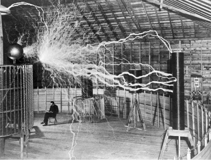 1899'da milyonlarca volt üreten " Tesla Bobininin " yanında oturan Tesla.